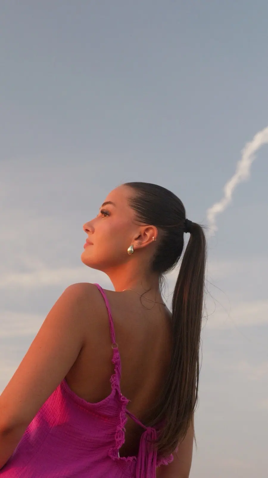 Profil en robe rose au coucher du soleil