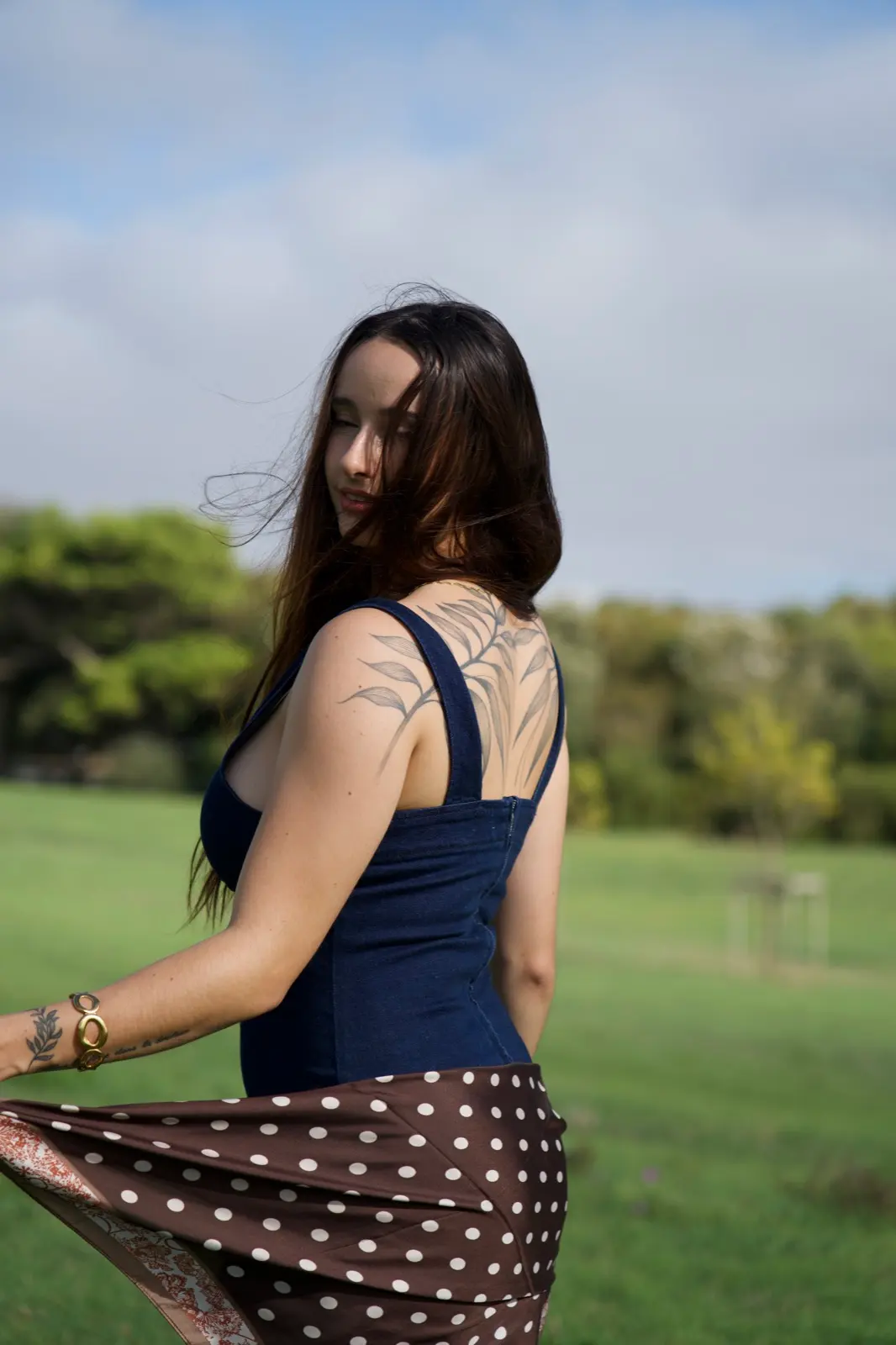 Mannequin en robe navy dans un champ, foulard au vent